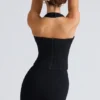 Den svarte stretch-korsetteren med halterneck-topper